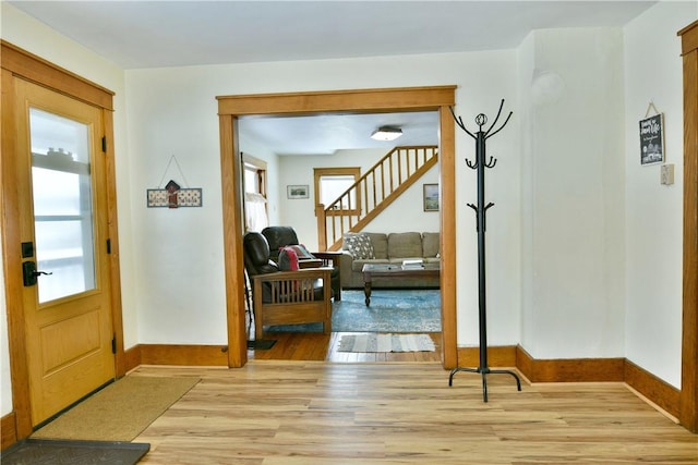 doorway featuring light wood-type flooring, stairs, and a wealth of natural light