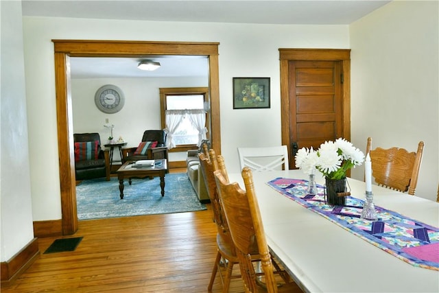 dining area featuring visible vents, baseboards, and wood finished floors