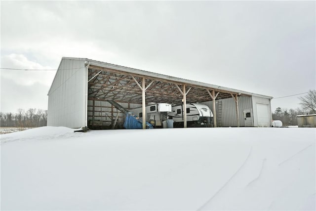 snow covered structure featuring a carport