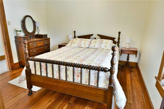 bedroom with wood finished floors and baseboards