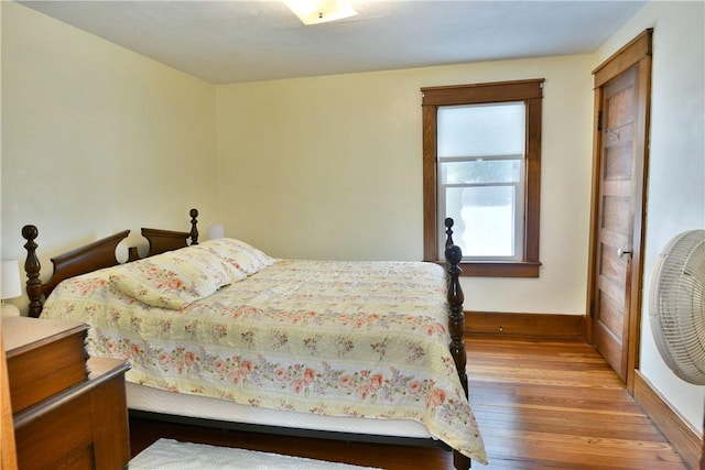 bedroom with baseboards and wood finished floors