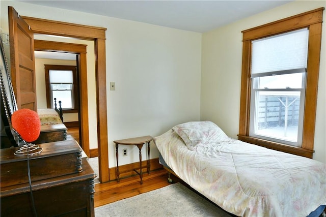 bedroom featuring baseboards and wood finished floors