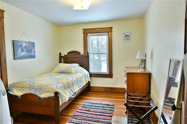 bedroom featuring light wood finished floors and baseboards