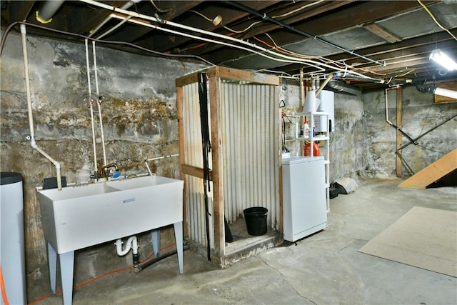 unfinished below grade area with water heater and a sink