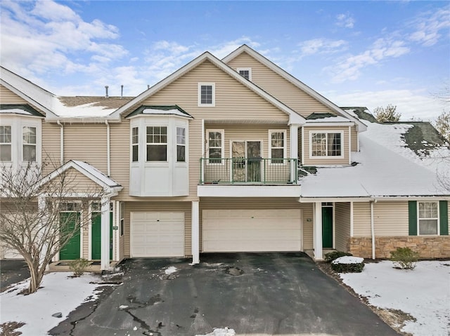 townhome / multi-family property featuring a garage, driveway, and a balcony