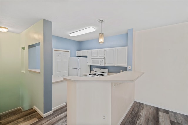 kitchen with light countertops, hanging light fixtures, white cabinets, white appliances, and a peninsula