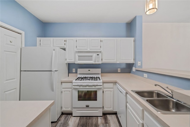 kitchen featuring light countertops, white appliances, a sink, and white cabinetry