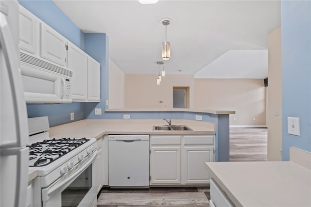 kitchen with light countertops, white appliances, a sink, and white cabinets