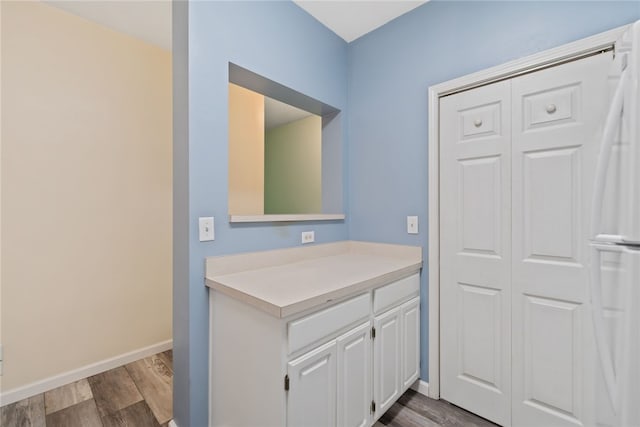 bathroom with vanity, baseboards, and wood finished floors