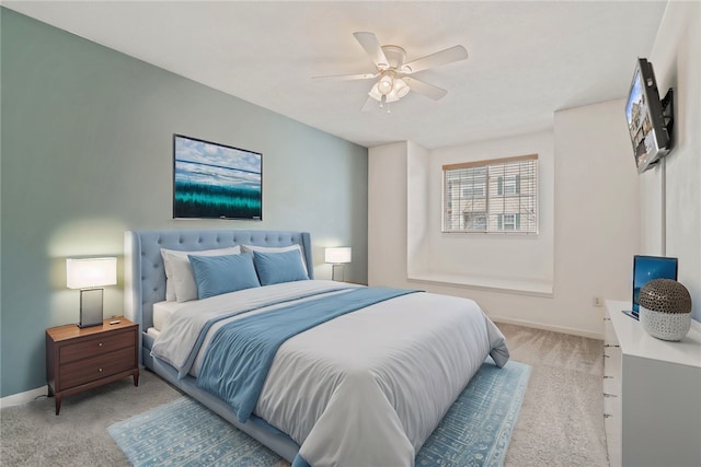 bedroom with light carpet, baseboards, and a ceiling fan