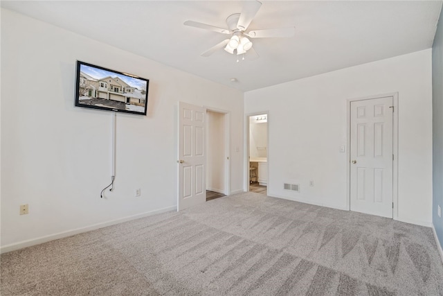 unfurnished bedroom featuring ensuite bath, carpet, baseboards, and ceiling fan