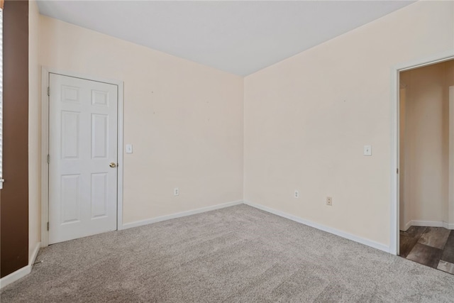 carpeted spare room featuring baseboards