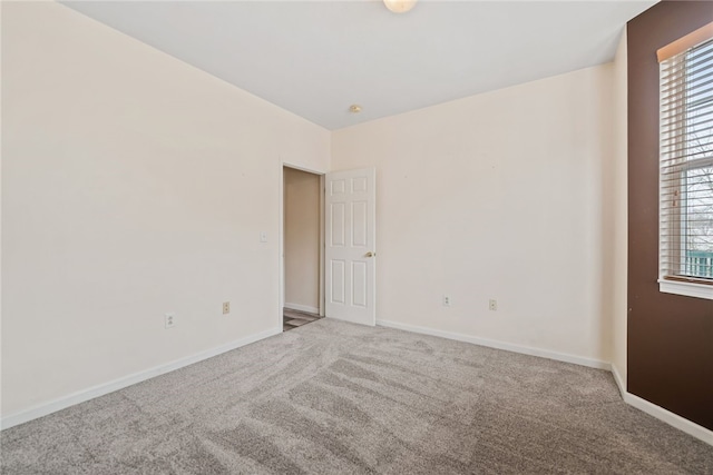 unfurnished room featuring carpet floors and baseboards