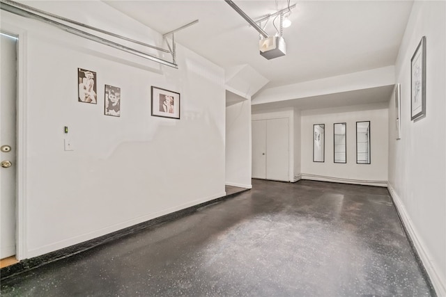 garage with a garage door opener and baseboards