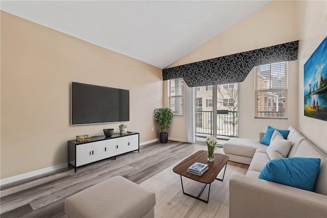 living room featuring lofted ceiling, baseboards, and light wood finished floors