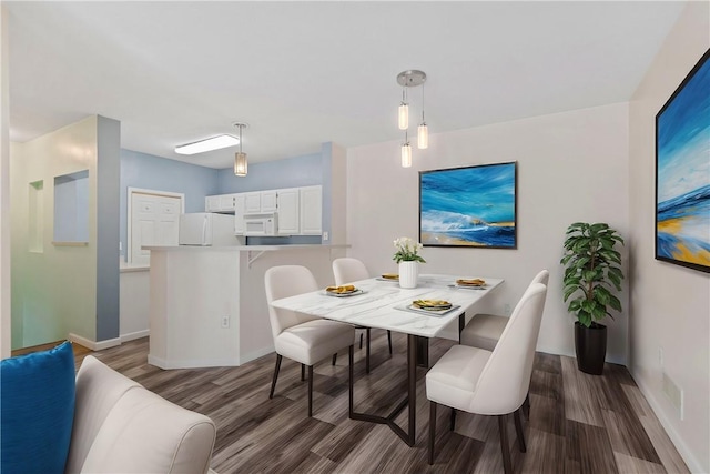 dining room featuring baseboards and dark wood-type flooring