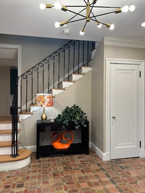 stairway with stone finish floor, baseboards, and ornamental molding