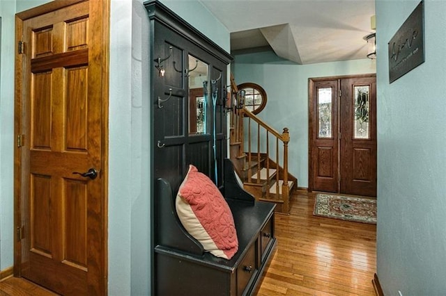 foyer with hardwood / wood-style flooring, stairs, and baseboards