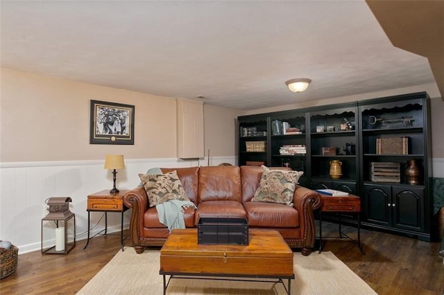 living room featuring dark wood-type flooring and wainscoting