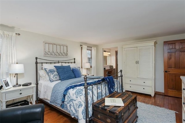 bedroom with dark wood finished floors and baseboards