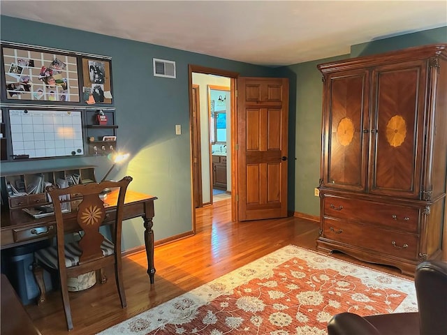 office space with light wood-type flooring, baseboards, and visible vents