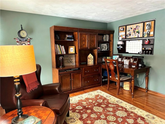 office area with light wood-style flooring and a textured ceiling