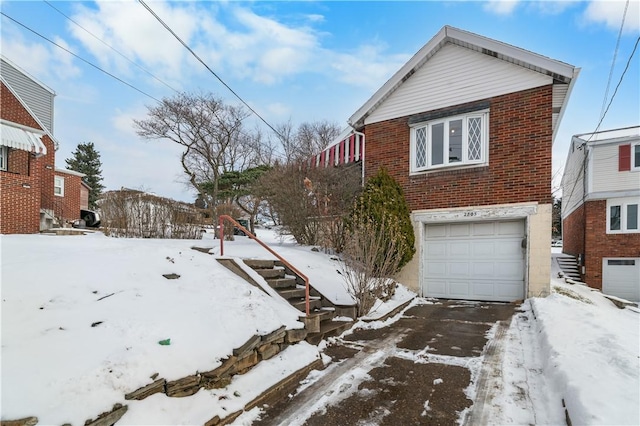 exterior space with brick siding, driveway, and an attached garage