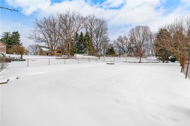 yard layered in snow featuring fence