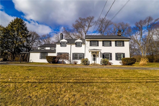 view of front of house with a chimney and a front lawn