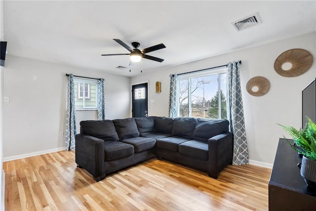 living area featuring a healthy amount of sunlight, visible vents, and wood finished floors