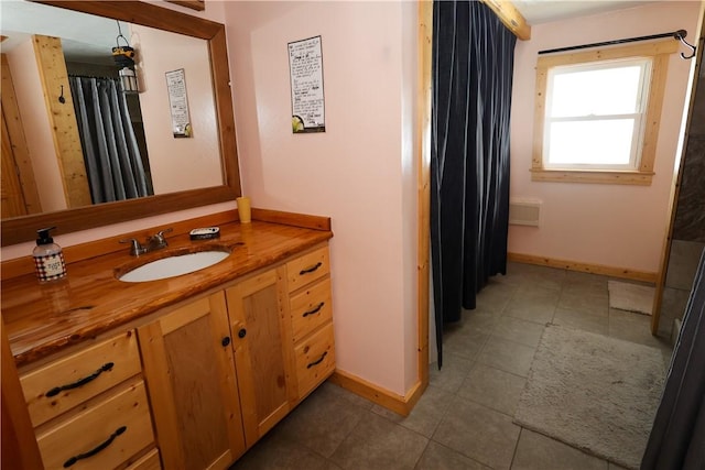 bathroom featuring tile patterned flooring, baseboards, and vanity