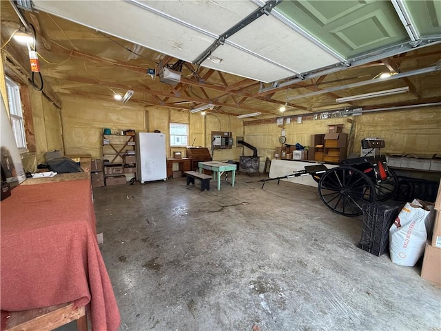 garage featuring freestanding refrigerator and a garage door opener