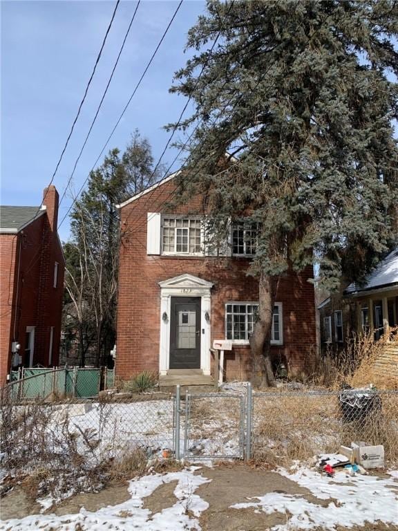 view of front of property with a fenced front yard, a gate, and brick siding