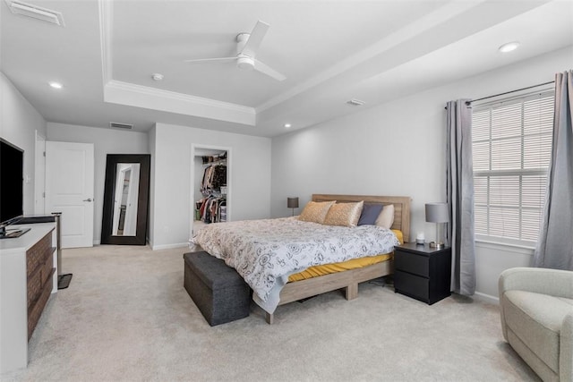 bedroom featuring a tray ceiling, visible vents, light carpet, and baseboards