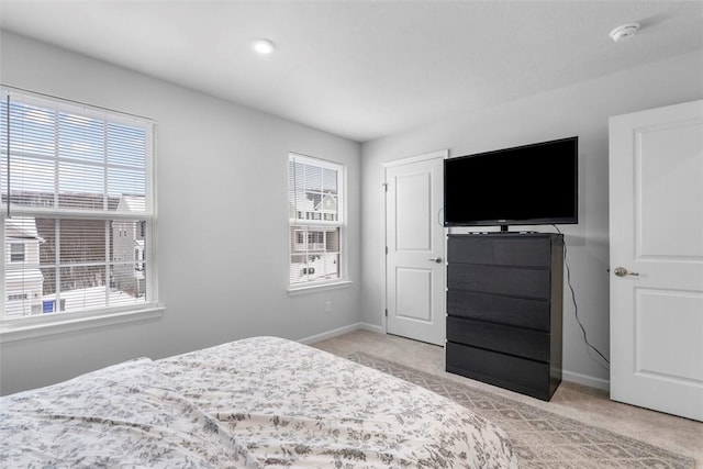 bedroom featuring light colored carpet and baseboards