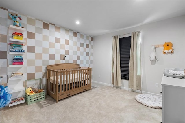 bedroom with light carpet, a nursery area, baseboards, and recessed lighting