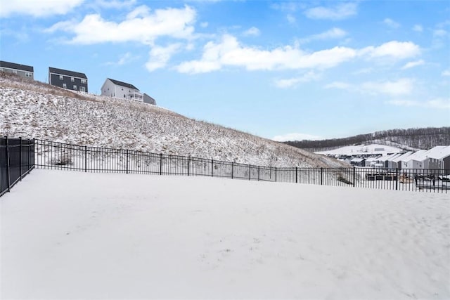 snowy yard featuring fence