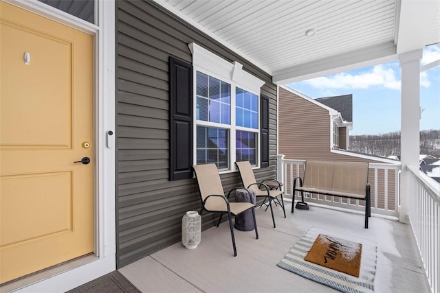 snow covered property entrance with a porch