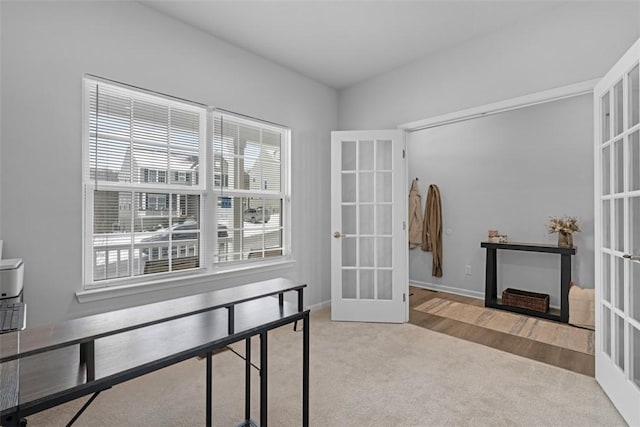 home office featuring light carpet, baseboards, and french doors