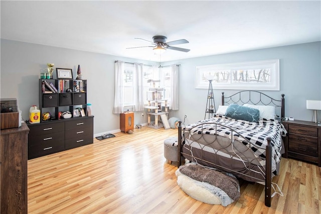 bedroom with a ceiling fan, light wood-type flooring, multiple windows, and baseboards