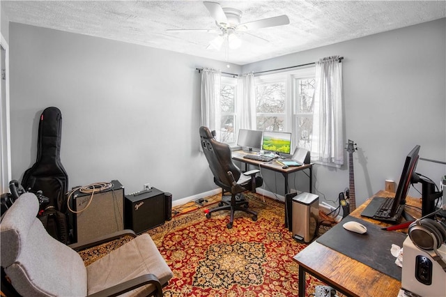 office featuring a textured ceiling, a ceiling fan, and baseboards