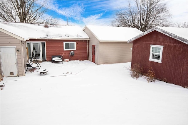 view of snow covered back of property