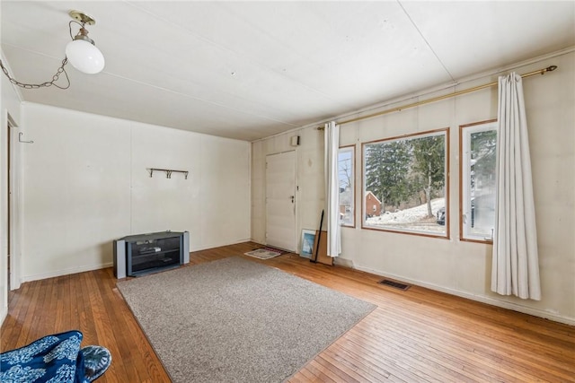 unfurnished living room with visible vents and wood finished floors