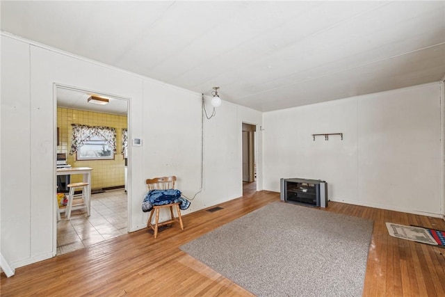 living area with wood finished floors and visible vents