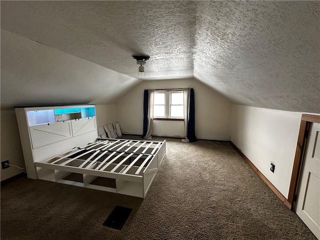 additional living space with carpet, vaulted ceiling, and a textured ceiling