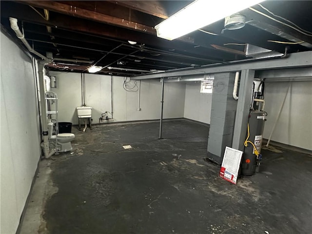 basement featuring gas water heater and a sink