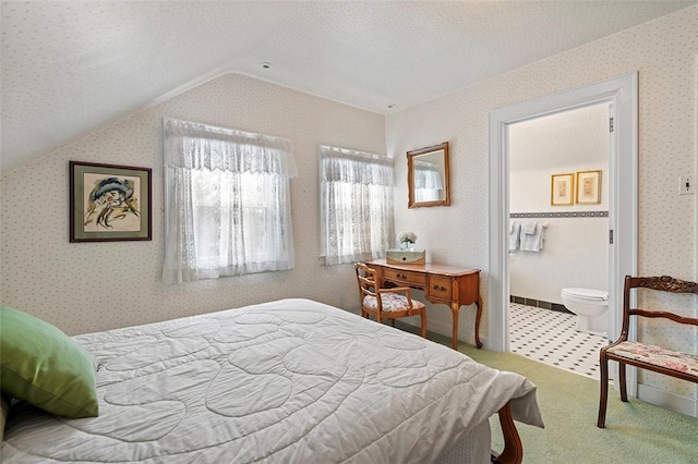 carpeted bedroom with wallpapered walls, vaulted ceiling, and a textured ceiling