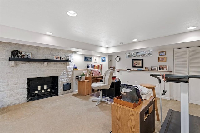 home office with light carpet, recessed lighting, and a stone fireplace