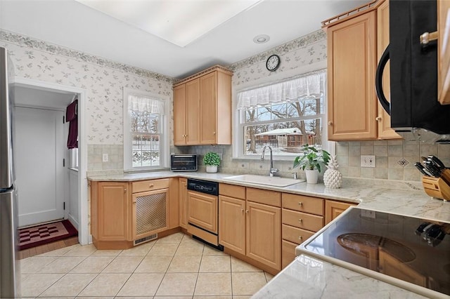 kitchen with paneled dishwasher, black microwave, light countertops, and a sink