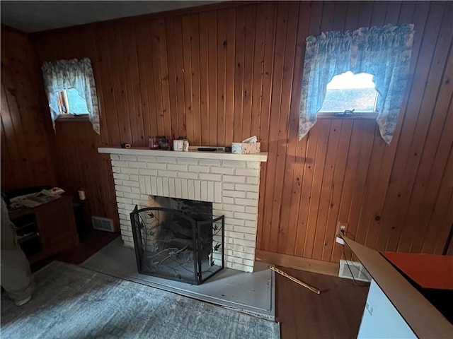 interior space featuring wood walls, a fireplace, and visible vents